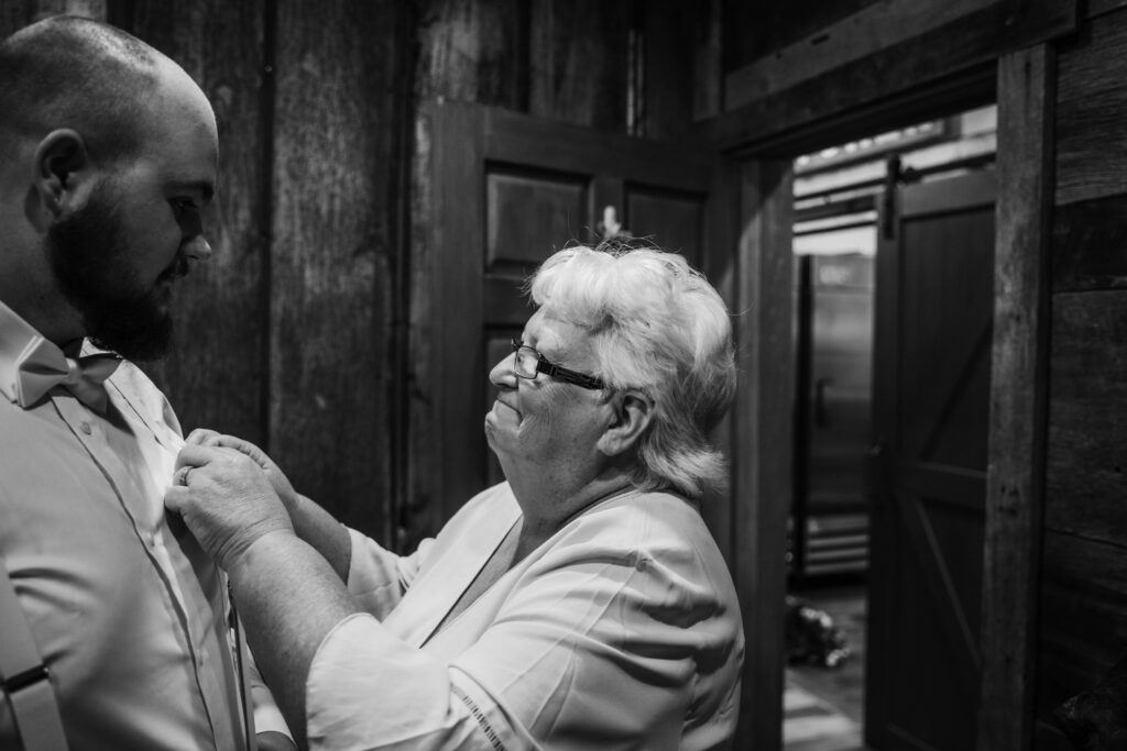 Grandmother adjusts boutonniere for her grandson who is getting married in Princeton, West Virginia.