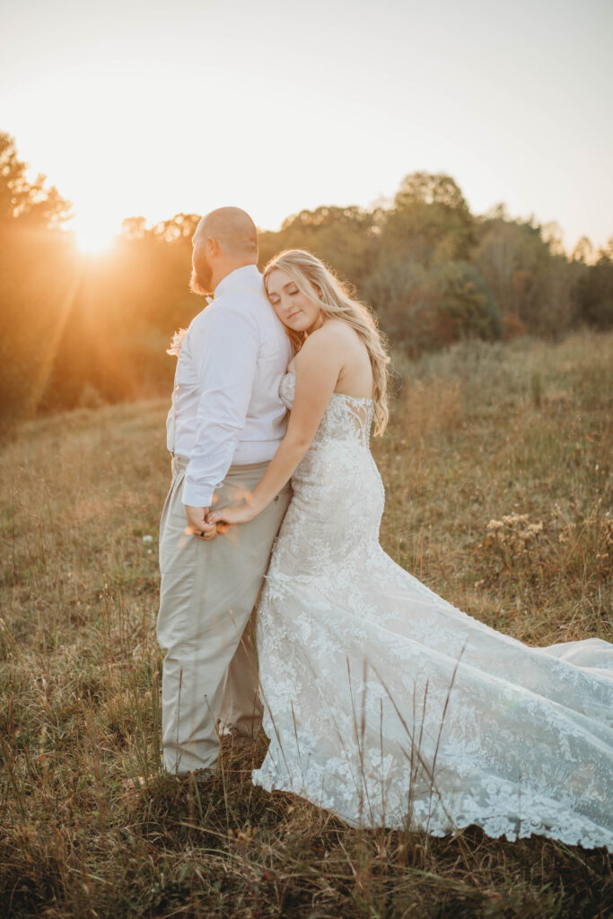 A wife holds your husbands hand at sunset at the Barn on Unity Farm in Princeton, West Virginia.