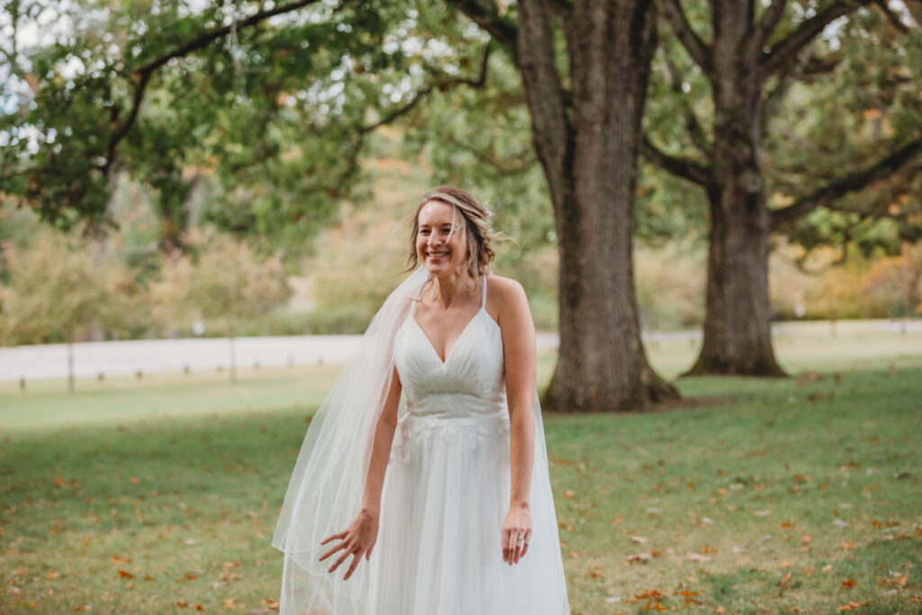 A bride sees her husband to be for the first time before the wedding and smiles with excitement. 