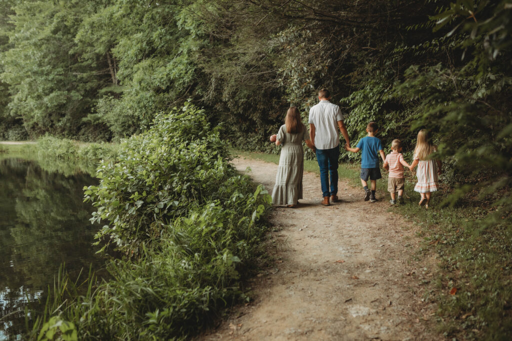 A family walk hand in hand next to a lake at Little Beaver State Park in West Virginia.