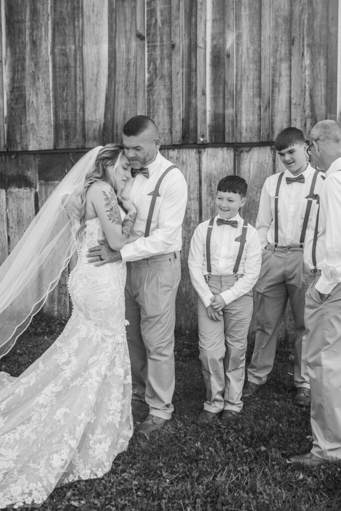 A bride and father embrace surrounded by family at a wedding in Princeton, West Virginia. 