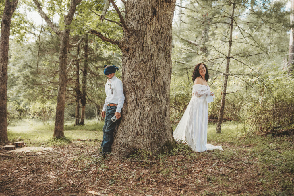 A couple hide from each other on two sides of a tree before a first look in Roanoke, Virginia.