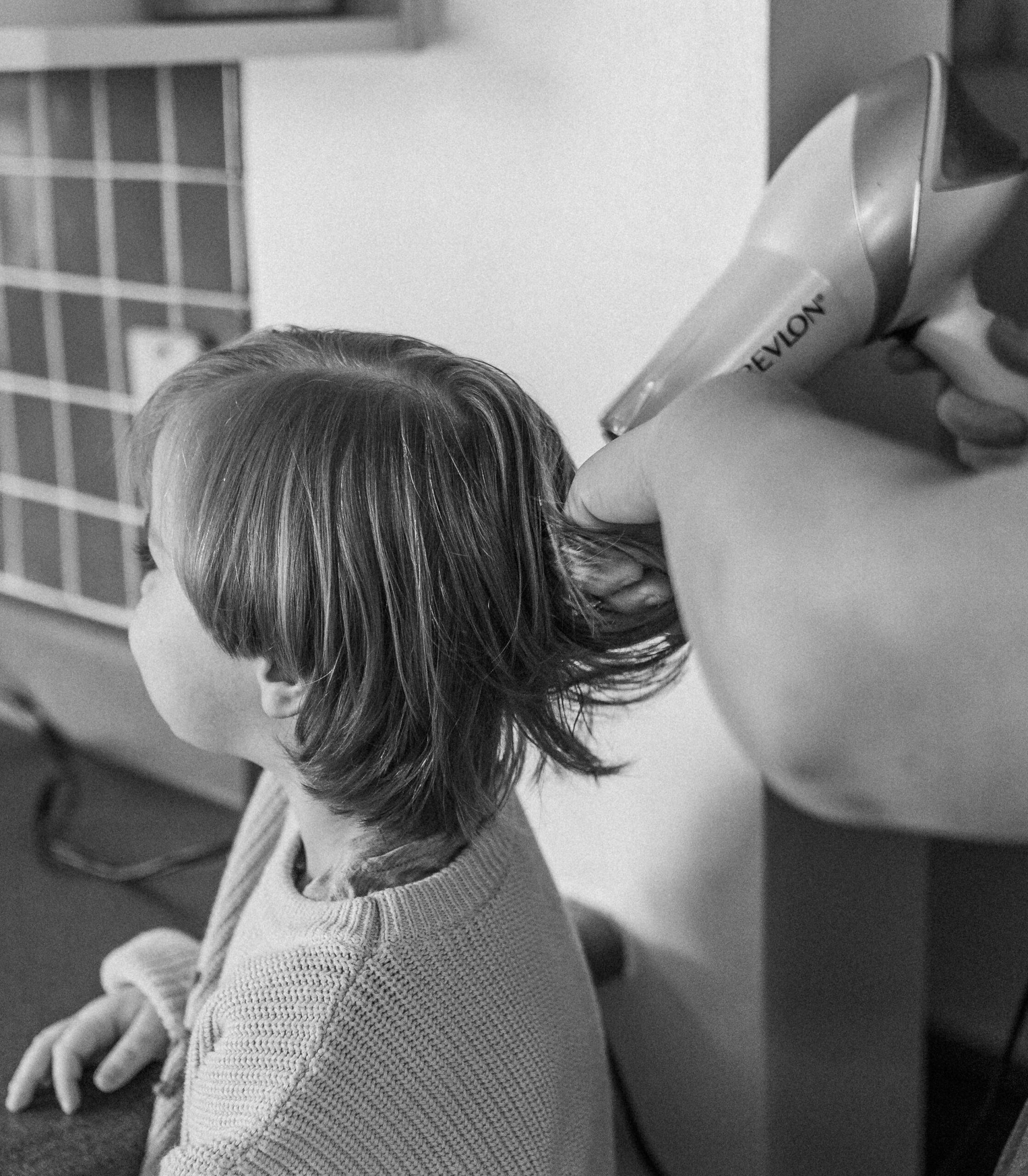 A boy has his hair blow dried by his mother at the kitchen table in Bluefield, West Virginia