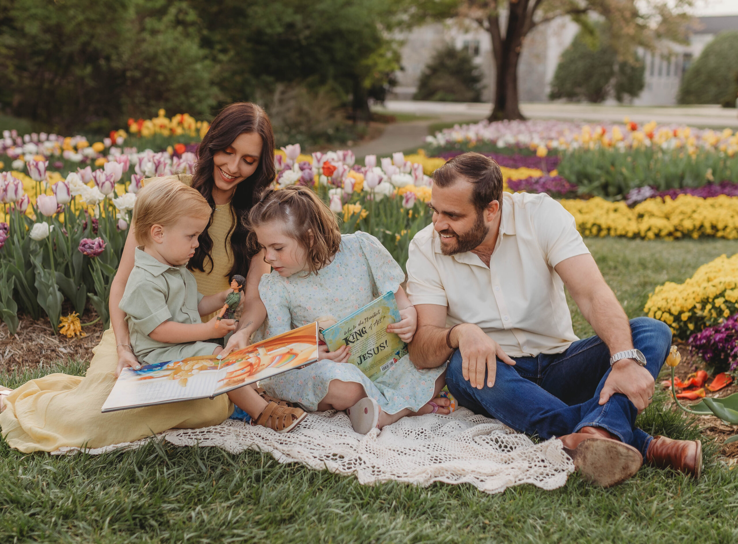 A family reads together while sitting amidst flowers at Hahn Horticulture Garden in Blacksburg, Virginia.
