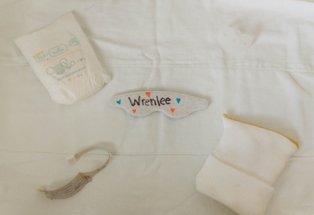 A baby's belongings from a Beckley, West Virginia Newborn Photography Session sit on a blanket.