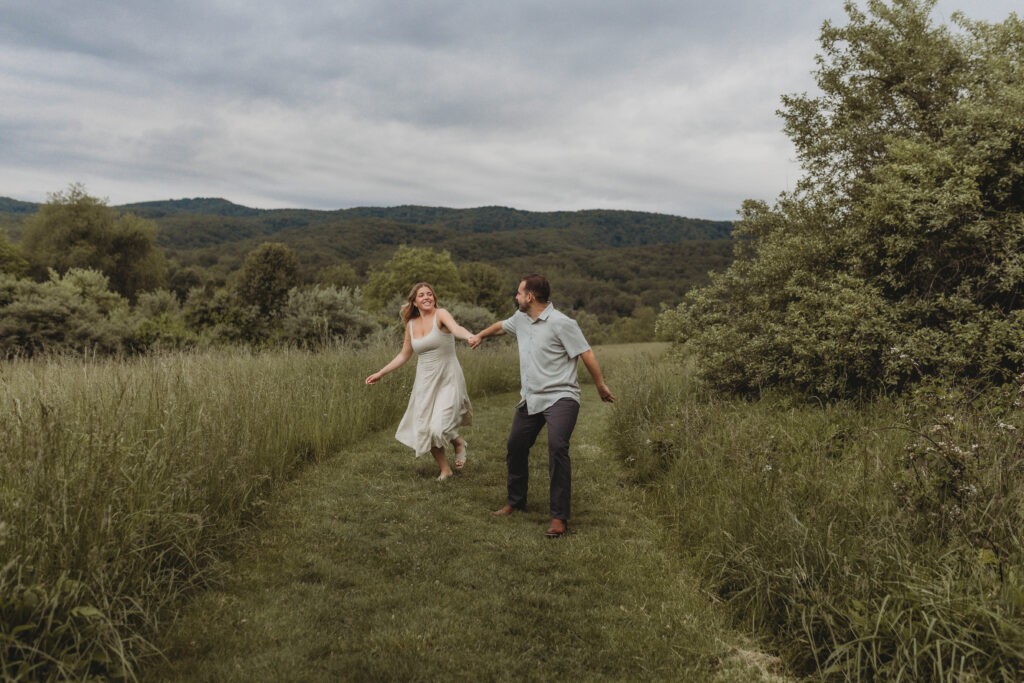 A couple runs towards the camera held by a Blacksburg, Virginia engagement photographer.