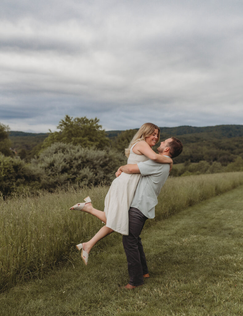 A man picks up a woman and lovingly looks into her eyes during engagement photos at Heritage Community Park in Blacksburg, Virginia.