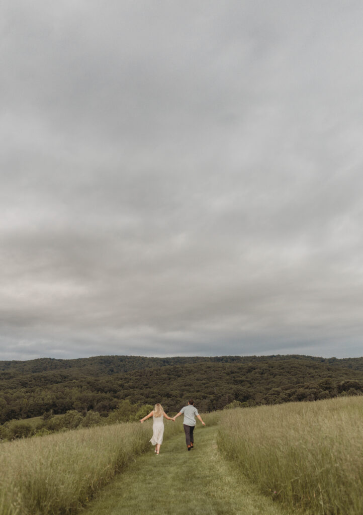 A distanced photo of a couple walking away into a field at Heritage Community Park in Blacksburg, Virginia.