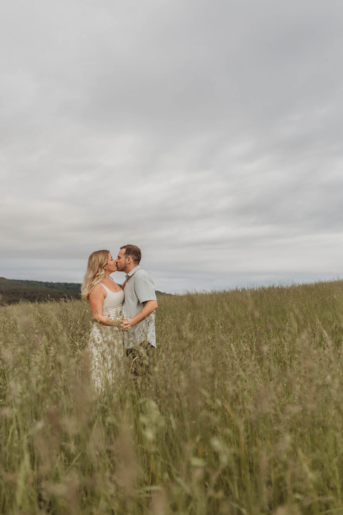 A couple hold hands and kiss during their engagement photos in Blacksburg, Virginia.