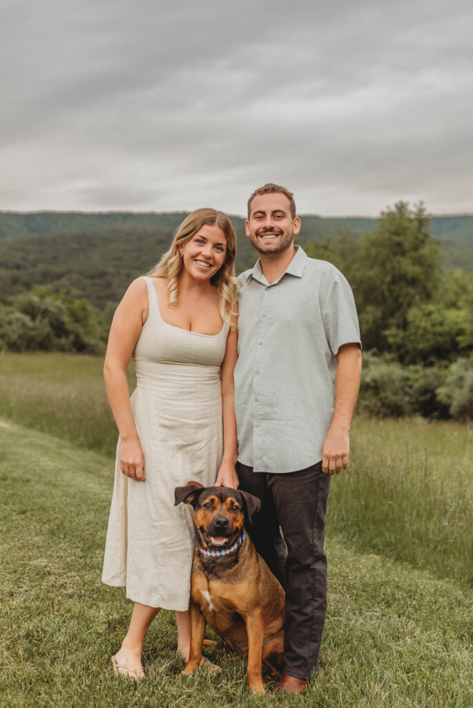A couple stand and pose with their dog during their engagement photos in Blacksburg, Virginia.
