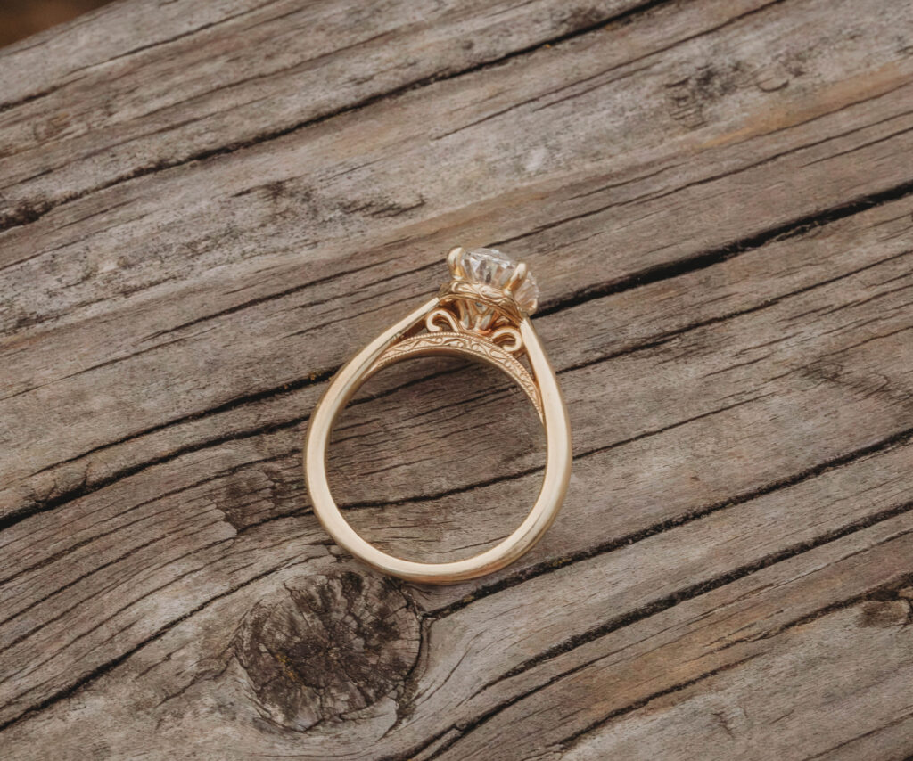 A beautiful golden ring sitting on a wooden table during engagement photos in Blacksburg, Virginia.