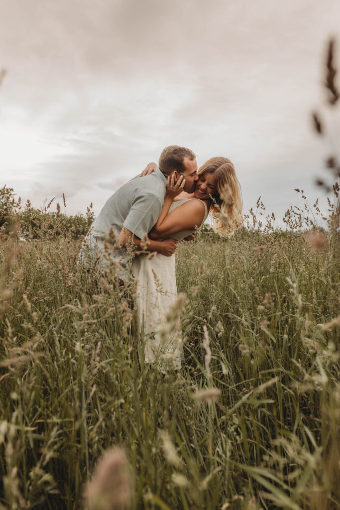 A woman and man cuddle and laugh together during engagement photos at Heritage Community Park in Blacksburg, Virginia.
