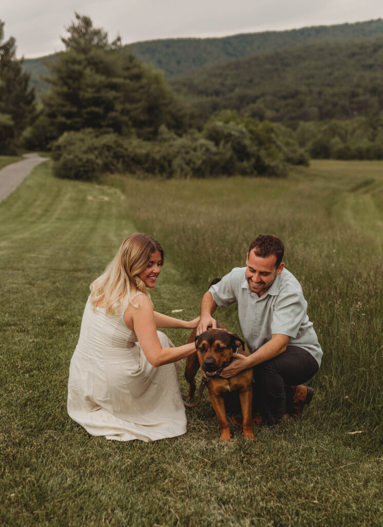 A couple pet their dog during engagement photos in Blacksburg, Virginia.