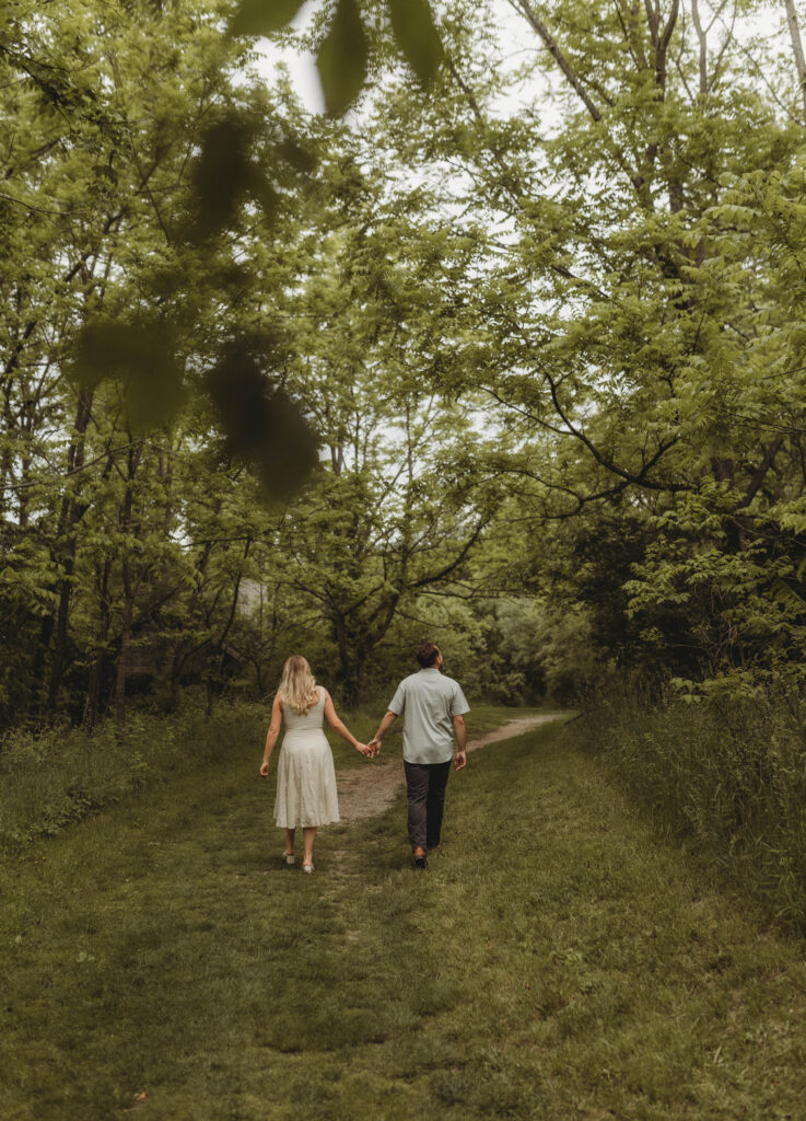 A couple hold hands and walk away during engagement photos in Blacksburg, Virginia.
