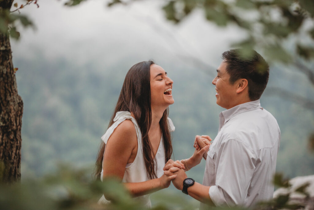 Couple laughs during dance at New River Gorge engagement photos.