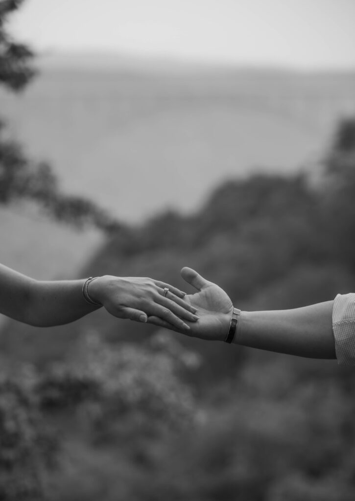 Two hands touch near the New River Gorge bridge during New River Gorge engagement photos.