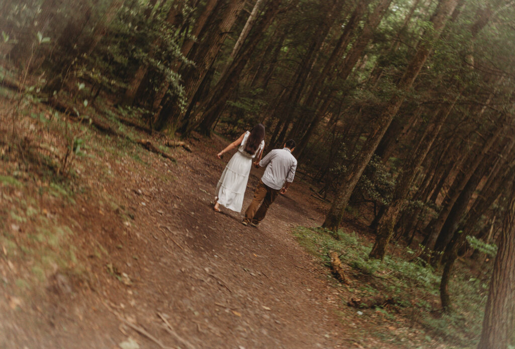 An out of focus image of a couple holding hands and walking on the Endless Wall Trail at the New River Gorge.