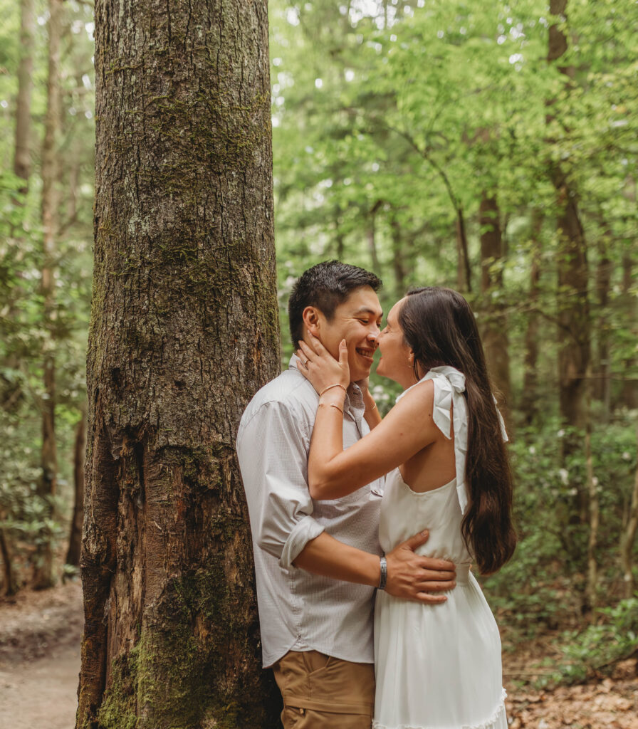 A couple touch noses before kissing during New River Gorge engagement photos.