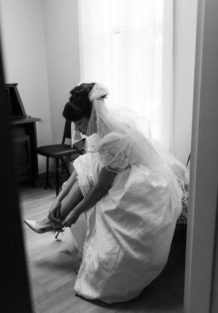A bride puts on her shoes at a Hahn Horticulture Wedding in Blacksburg, Virginia. 