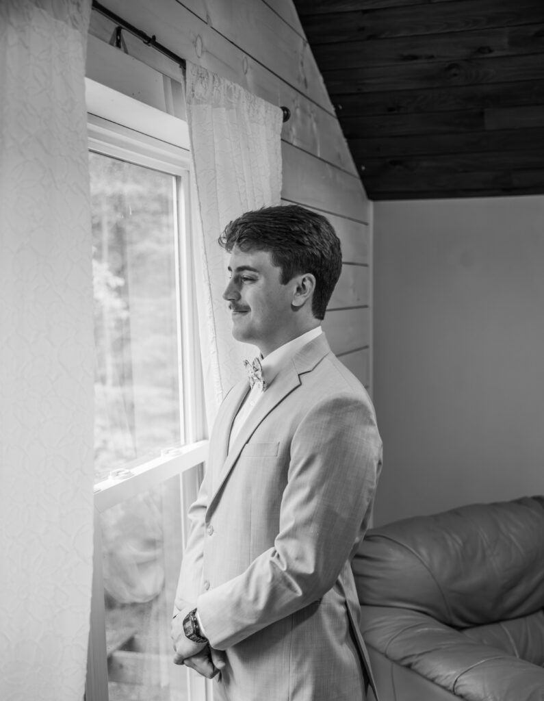 Groom looking out of the window at a Vintage Valley Wedding. 
