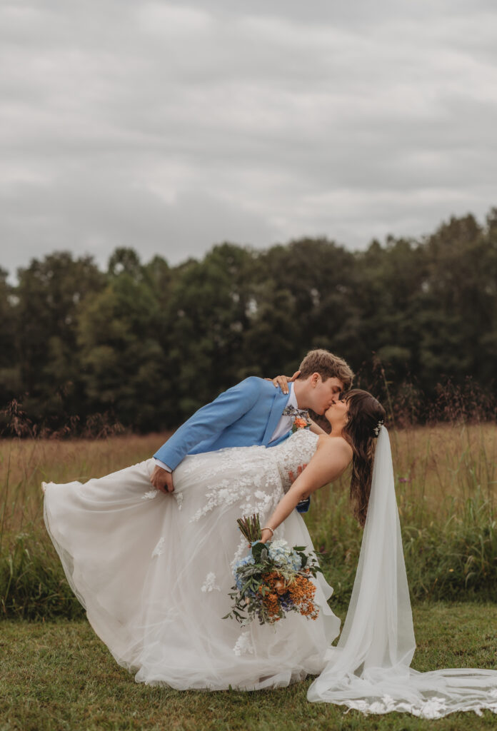 The groom dips the bride and kisses her at a Vintage Valley Wedding. 