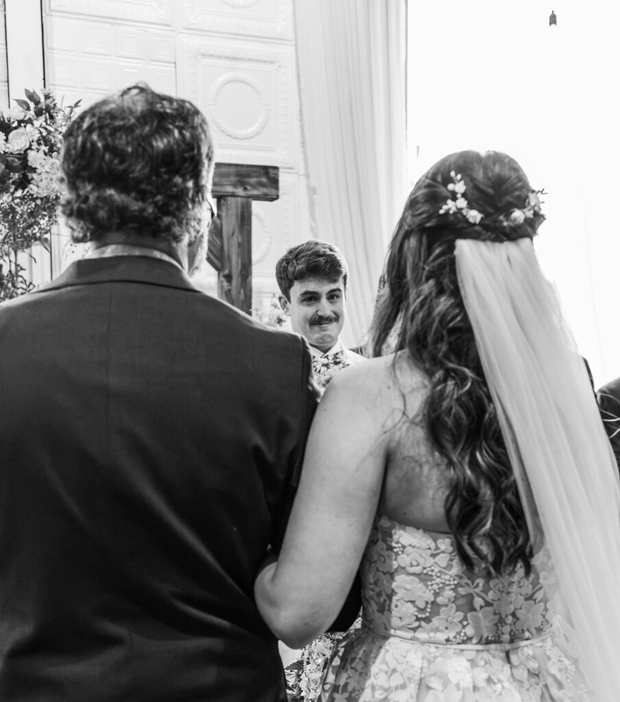 A groom crying while seeing his bride 
